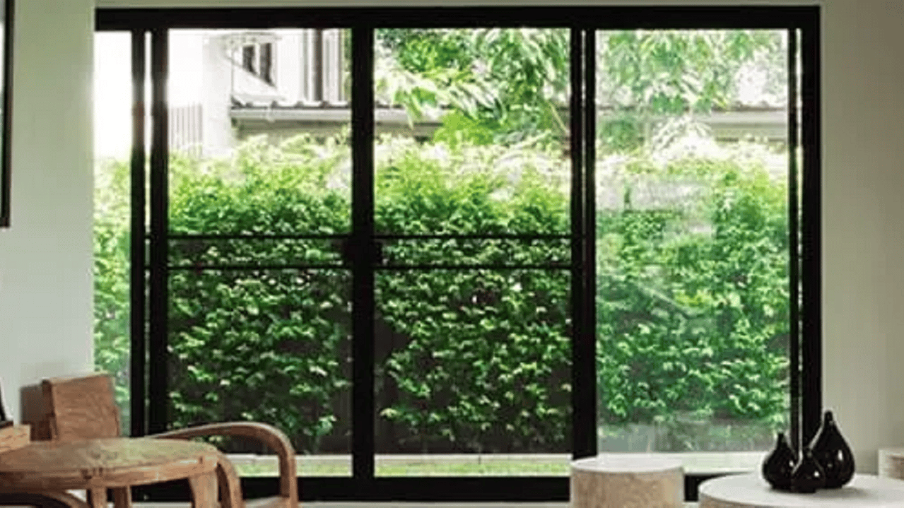 Sala com janela grande e arbusto do lado de fora