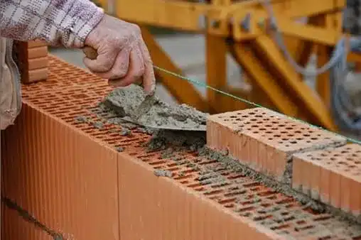 pedreiro construindo uma parede de tijolos