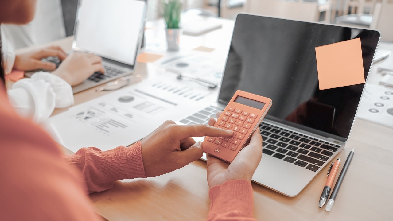 mão feminina utiliza calculadora para gerenciar custos