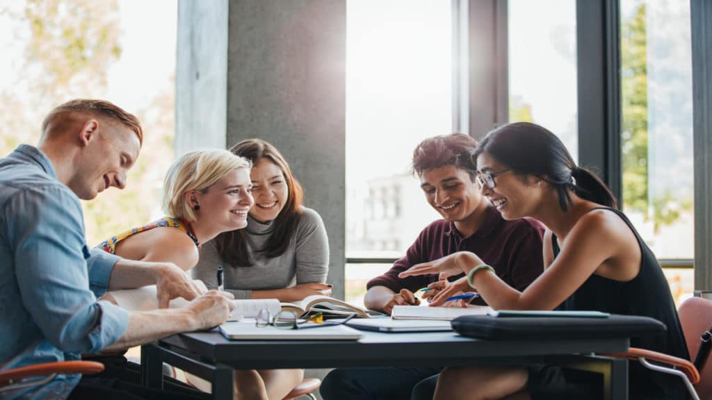 Pessoas em uma mesa conversando em um ambiente de estudo.