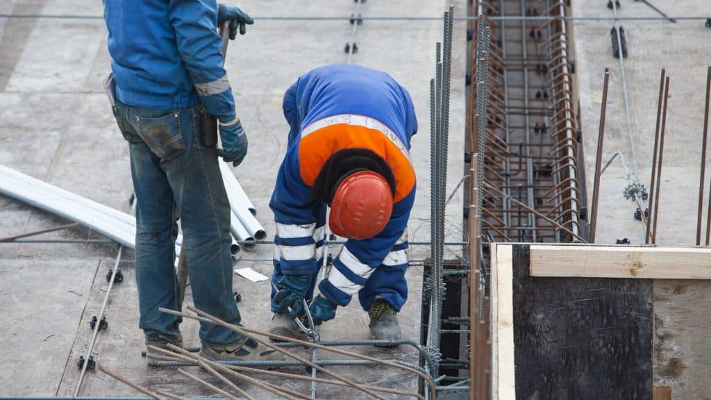 Dois trabalhadores montando uma estrutura de aço